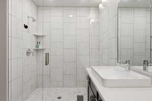 Contemporary bathroom featuring a frameless glass shower enclosure, white subway tile shower surround, and a white rectangular vessel sink with a chrome faucet