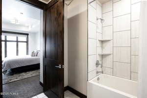 Bathroom featuring shower / bath combination with curtain, connected bathroom, and light tile patterned floors