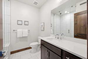 Contemporary bathroom featuring a dark wood-finish vanity with an integrated white sink, chrome fixtures, and a frameless mirror