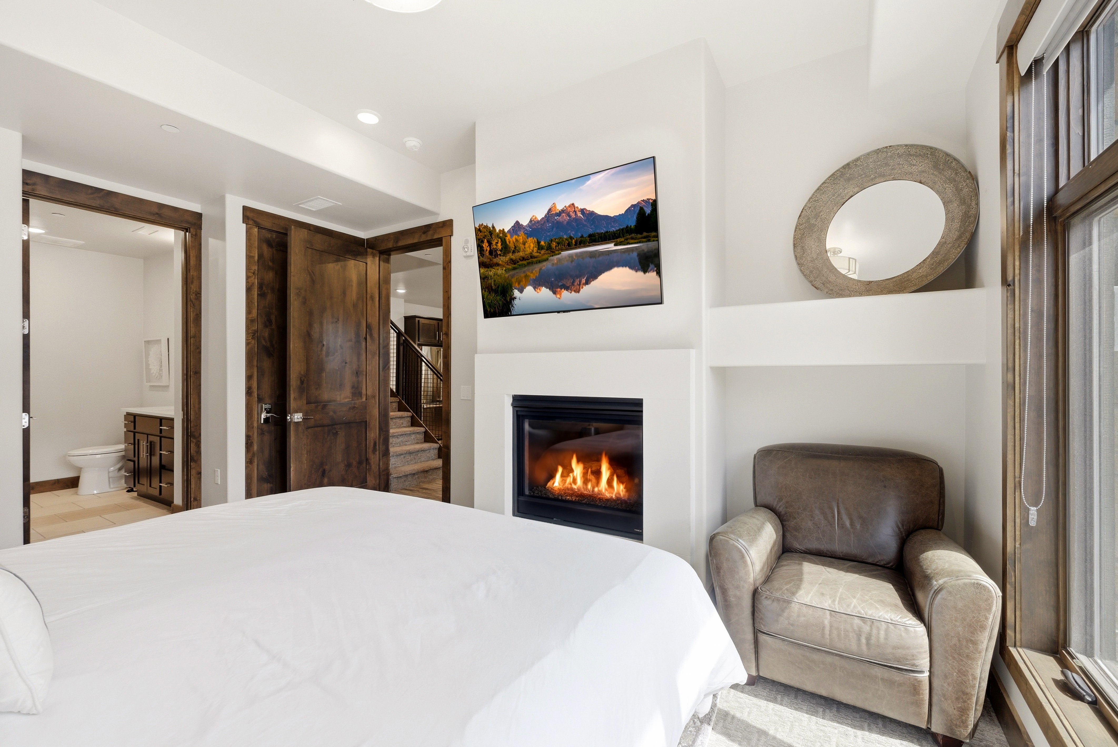 White walls featuring a built-in fireplace, a large window with wood trim, and recessed lighting