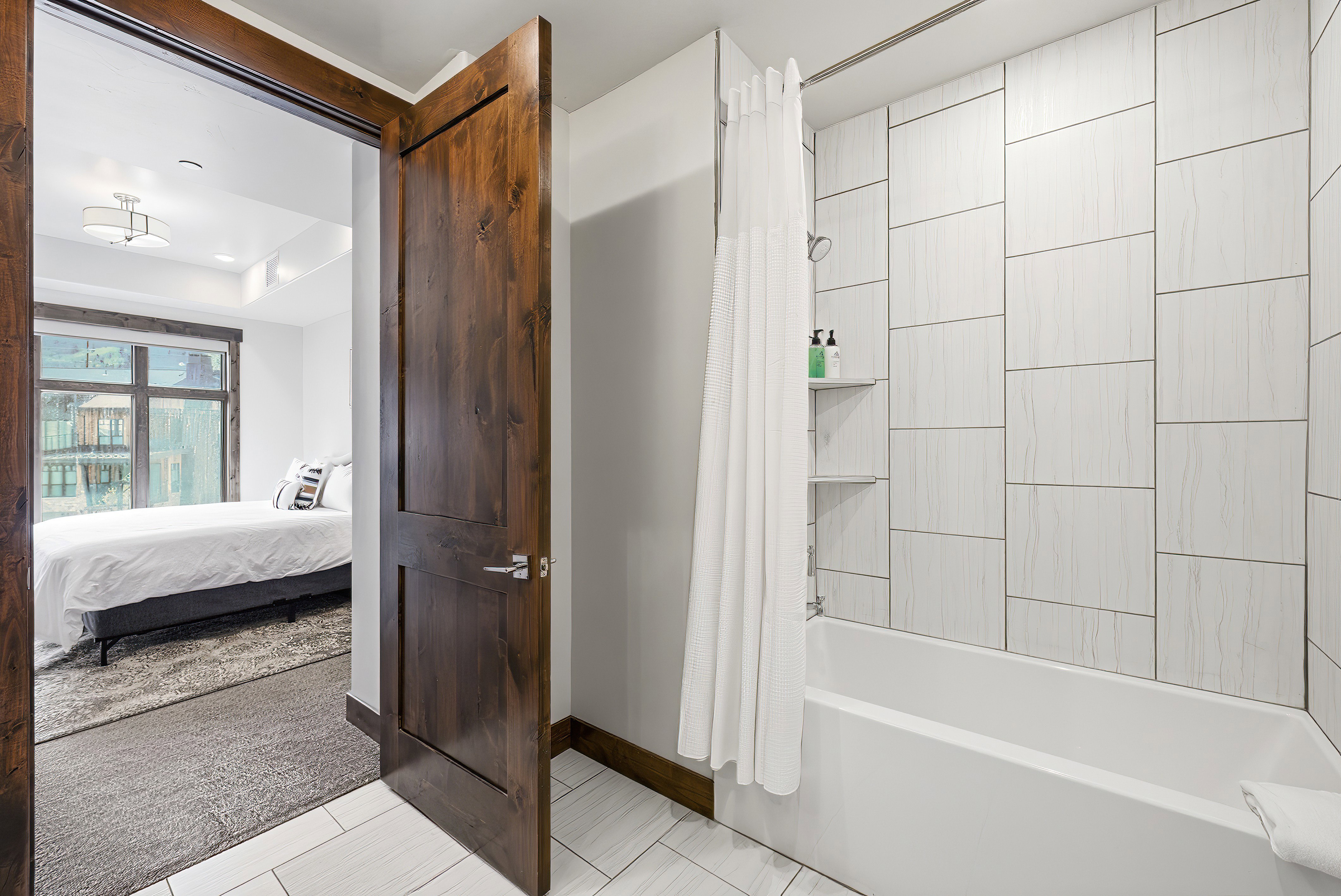 White tiled shower with built-in shelving and tub