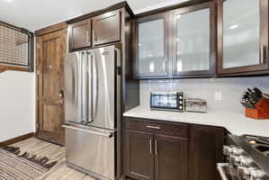 Stainless steel French door refrigerator set against rich wood-finish cabinetry