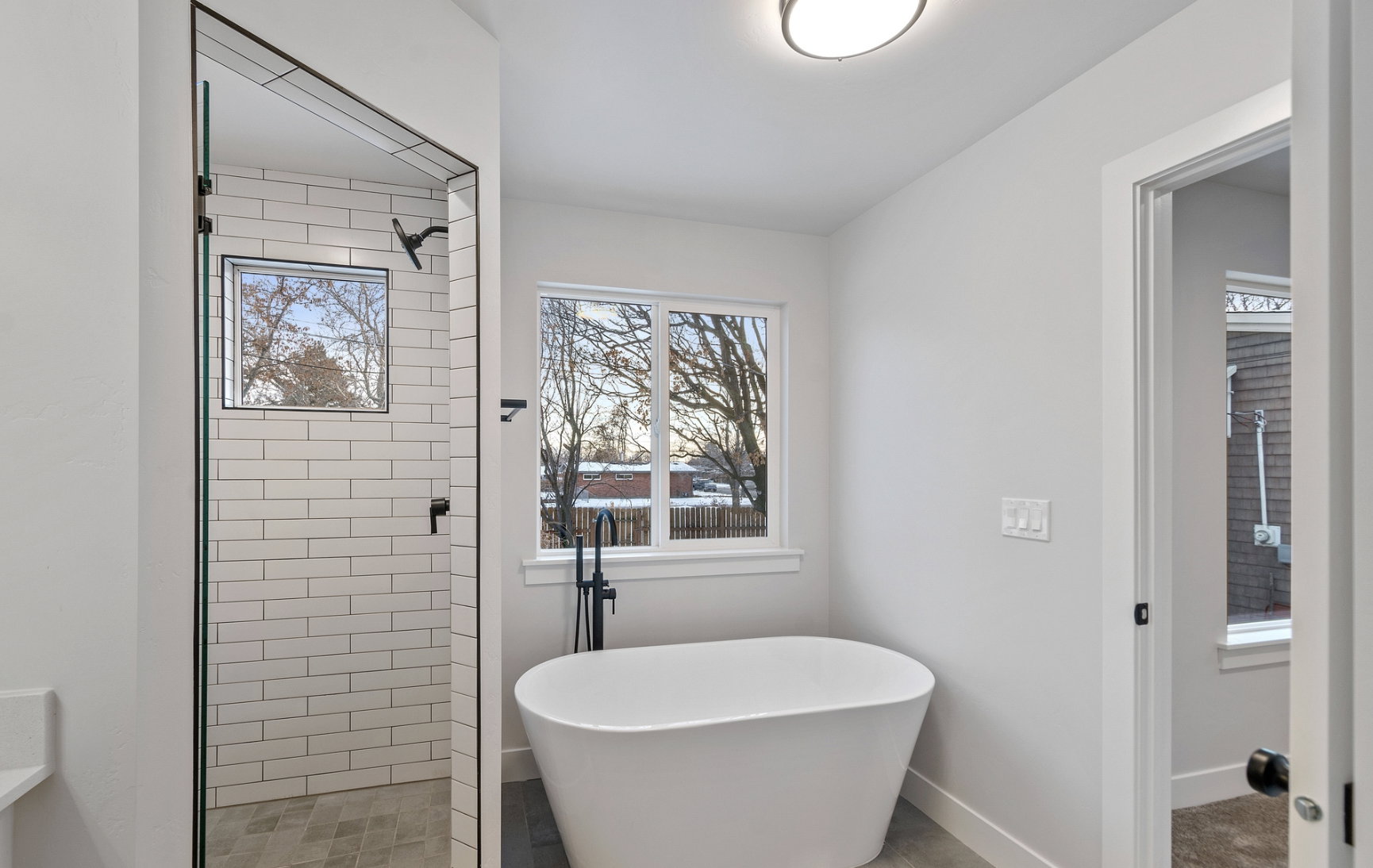 Primary bathroom featuring soft close cabinets, a glass shower door, and a stand alone tub