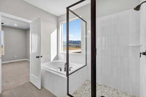 Bathroom featuring a bath, tile patterned flooring, and a stall shower