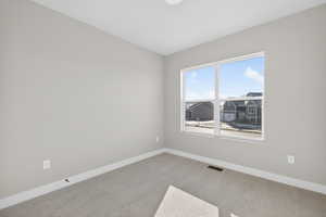 Carpeted spare room with baseboards