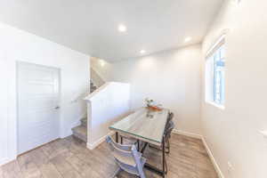 Dining space featuring light wood-type flooring, recessed lighting, and stairway