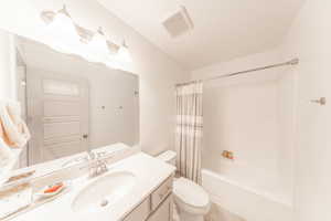 Bathroom with shower / tub combo with curtain and vanity