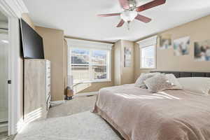 Carpeted bedroom with ceiling fan and baseboards