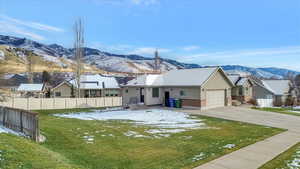 View of front of house featuring brick siding, concrete driveway, stucco siding, a mountain view, and a residential view