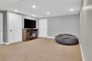 Living area featuring recessed lighting, carpet floors, and a glass covered fireplace