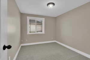 Carpeted empty room featuring baseboards