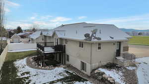 Back of house featuring a fenced backyard, a wooden deck, and a patio