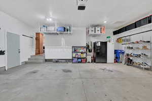 Garage featuring black fridge and a garage door opener
