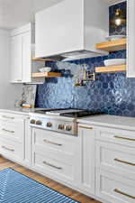 Kitchen featuring open shelves, white cabinetry, light stone countertops, and a textured ceiling