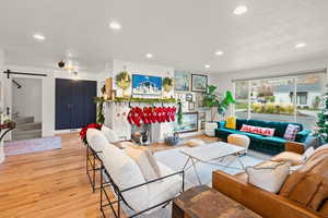 Living area featuring stairs, light wood-style flooring, a barn door, and recessed lighting