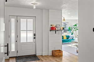 Foyer entrance with light wood-type flooring and recessed lighting