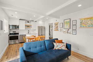 Living area featuring recessed lighting, beamed ceiling, and light wood finished floors