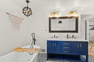 Full bathroom featuring double vanity and a freestanding tub
