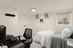 Bedroom featuring carpet, an office area, and a closet