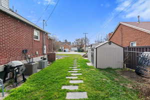 View of yard featuring a storage shed and a residential view