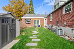 View of green lawn with a storage shed