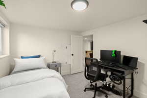 Bedroom featuring light colored carpet and a desk
