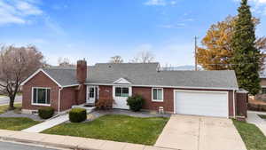 View of front of house with roof with shingles, a garage, concrete driveway, a front lawn, and brick siding