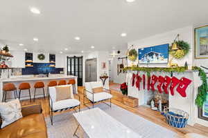 Living room featuring a barn door, light wood-style flooring, and recessed lighting