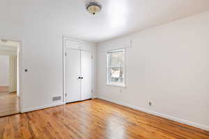 Unfurnished bedroom with light wood-style flooring and a closet