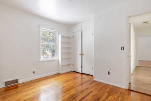 Unfurnished bedroom featuring light wood-style floors and a closet