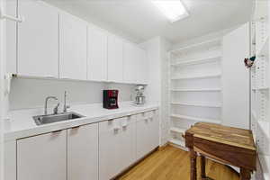 Kitchen featuring light countertops, white cabinets, and light wood-style floors