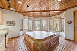 Game room with healthy amount of natural light, wood ceiling, light tile patterned floors, and recessed lighting