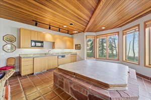Kitchen with wood ceiling, track lighting, light brown cabinets, dark tile patterned floors, and dishwasher