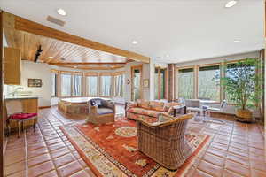 Living room with light tile patterned floors, plenty of natural light, and recessed lighting
