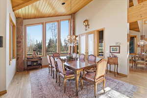 Dining space with a chandelier, wood ceiling, plenty of natural light, french doors, and light wood-style flooring