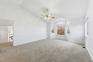 Primary Suite with carpet floors, ceiling fan, and high vaulted ceiling