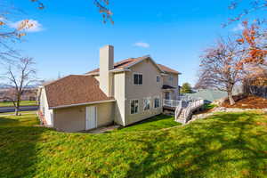Back of property featuring roof with shingles, a yard, a chimney, and a wooden deck
