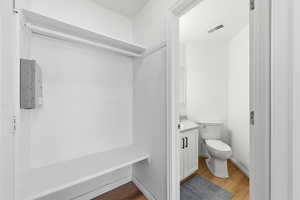 Half bathroom with vanity and light wood finished floors. Mud room off garage