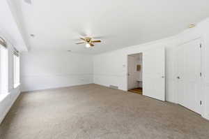 Carpeted family room off Kitchen area ornamental molding and ceiling fan