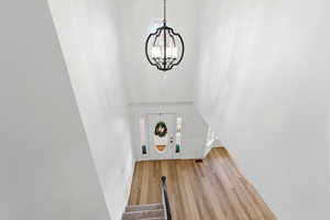 Foyer featuring stairway, wood finished floors, and a chandelier
