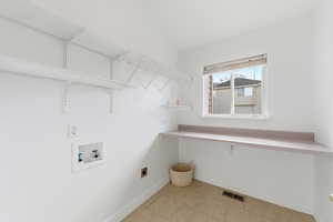 Washroom featuring washer hookup, light tile patterned floors, and electric dryer hookup