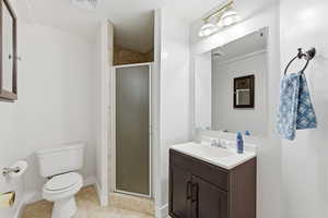 3/4 bathroom with a stall shower, vanity, and light tile patterned floors