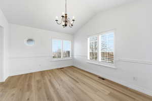 Formal Dining with a chandelier, vaulted ceiling, and light wood-type flooring