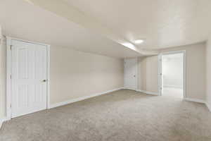 Bonus room with light carpet and a textured ceiling