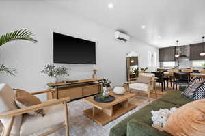 Living area with recessed lighting and a wall mounted AC