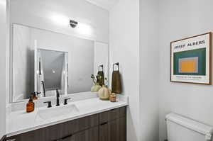 Half bathroom with vanity and toilet