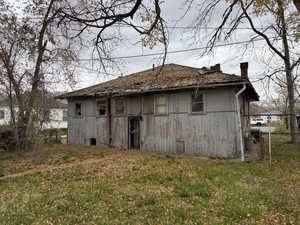 Rear view of house with a yard and a chimney