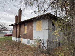View of property exterior with a chimney and brick siding