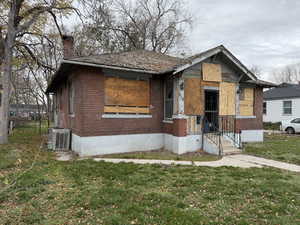Bungalow featuring brick siding and a chimney