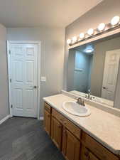 Spacious Bathroom with vanity, a textured ceiling, and dark carpet